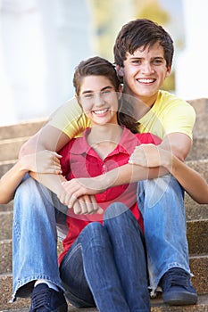 Teenage Couple Sitting On College Steps Outside