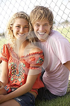 Teenage Couple Sitting In Playground