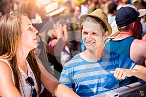 Teenage couple at summer music festival enjoying themselves