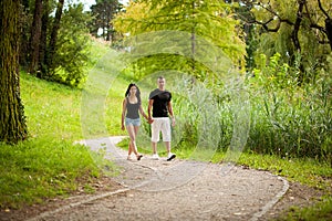 Teenage couple walks on a late summer afternoon in park