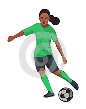 Teenage dark-skinned girl playing women& x27;s football in green uniform dribbling the ball and going to kick a ball