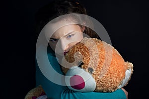 Teenage depression, girl hugging bear