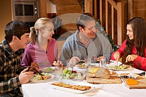 Teenage Family Enjoying Meal In Alpine Chalet