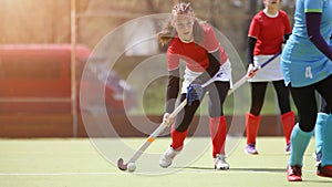 Teenage field hockey player in attack with ball