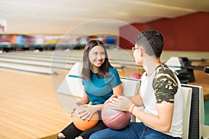 Teenage Friends With Bowling Balls In Club