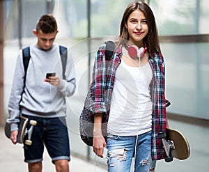 Teenage friends carrying skateboards in the city