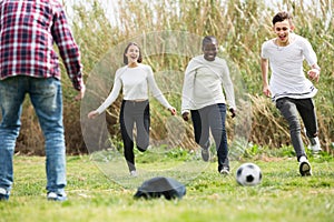 Teenage friends playing football