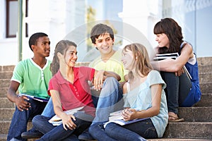 Teenage Friends Sitting On College Steps Outside