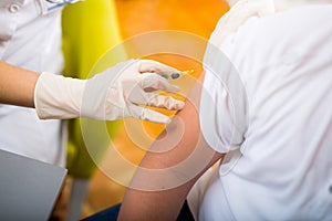 Teenage getting vaccination in his arm