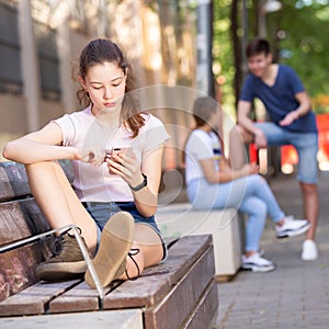 Teenage girl absorbed in social networks on phone