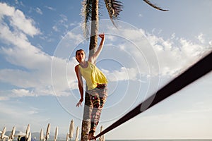 Teenage girl balancing on slackline with sky view photo