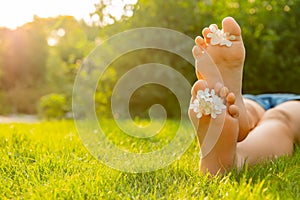 Teenage girl with beautiful hortensia flowers lying on green grass outdoors, closeup. Space for text