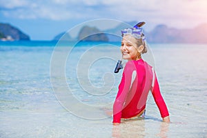 Teenage girl in bikini carrying scubadiving equipment