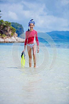 Teenage girl in bikini carrying scubadiving equipment photo