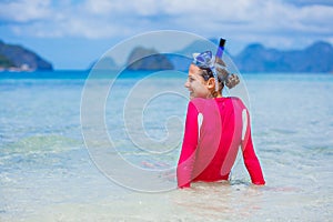 Teenage girl in bikini carrying scubadiving equipment