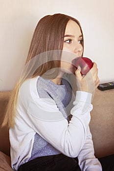 A teenage girl bites an apple