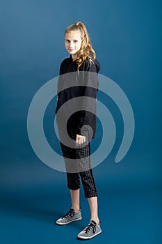 Teenage girl in black hoodie and plaid trousers