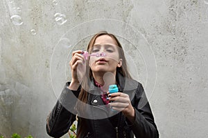 Teenage girl blowing soap bubbles