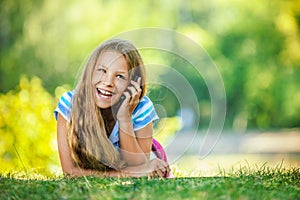 Teenage girl in blue blouse lying on grass
