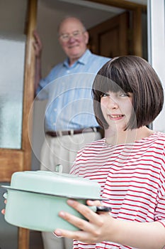 Teenage Girl Bringing Meal For Elderly Male Neighbour