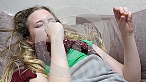 Teenage girl buries spray from a runny nose. She has a cold