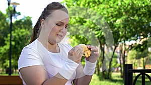 Teenage girl cannot resist temptation to eat hamburger, addiction to junk food