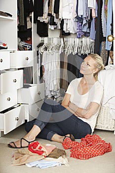 Teenage Girl Choosing Clothes From Wardrobe In Bedroom