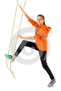 Teenage girl climbing rope ladder