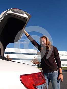 Teenage girl closing car trunk