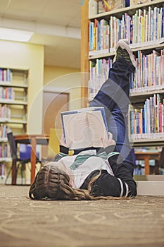 Teenage Girl with Converse High Tops Reading in Library