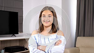 Teenage girl crossing her arms and smiling naturaly in front of the camerA