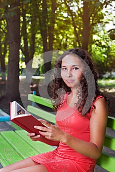 Teenage girl with curly hair reading book