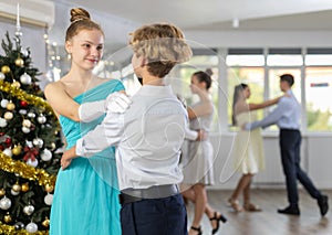 Teenage girl dancing ballroom dance with boy during New Year party