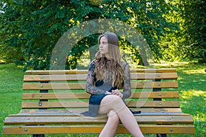 Teenage girl on date waiting sitting on bench in park