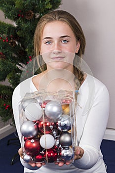 Teenage girl decorating New Year tree