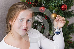 Teenage girl decorating New Year tree