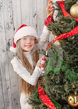 Teenage girl decorating New Year tree at home