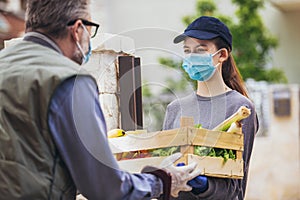 Teenage girl is delivering some groceries to an elderly person, during the epidemic coronovirus