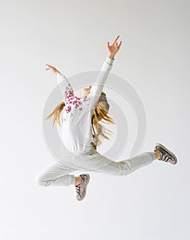 Teenage girl do a split leap in the air.