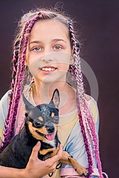 A teenage girl with a dog in her arms. The little girl had a pet chihuahua