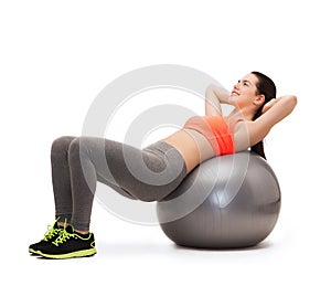 Teenage girl doing exercise on fitness ball