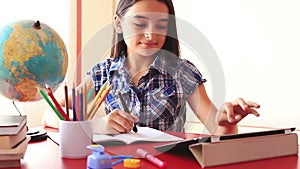 Teenage girl doing homework on tablet pc