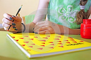 A teenage girl draws on a notebook