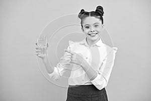 Teenage girl drinking water from glass isolated on blue background. Daily life health. Happy teenager, positive and