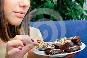 Teenage girl eating chocolate cookies at home