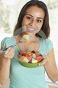 Teenage Girl Eating Fresh Fruit Salad