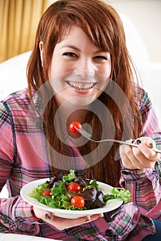 Teenage Girl Eating Plate Of Healthy Salad