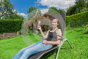 Teenage girl eating popsicles in a deckchair