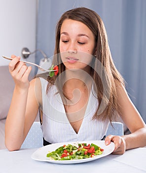 Teenage girl is enjoying tasty green salad