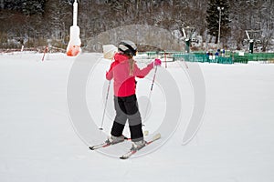 Teenage girl equipped for skiing on snowy slope at
